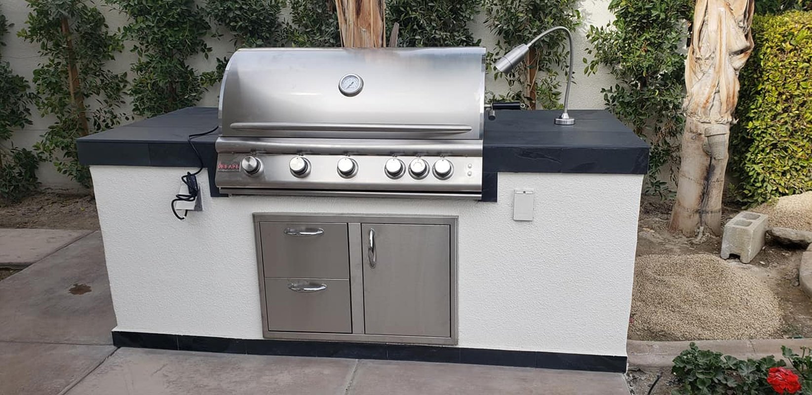 Compact freestanding white outdoor grill island with storage drawers